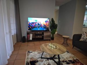sala de estar con TV y mesa de centro en Mandy & Mos' Holiday Townhouse, en Four Ways