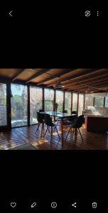 a dining room with a table and chairs on a wooden floor at MASCHWITZ , verde y luz in Maquinista Savio