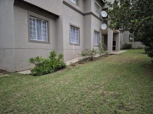 a house with a grass yard in front of it at Mandy & Mos' Holiday Townhouse in Four Ways