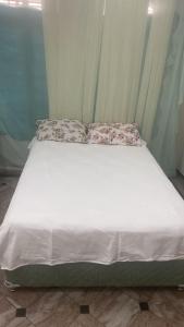 Una cama con dos almohadas encima en una habitación. en Apartamento em Adrianópolis confortável, en Manaus