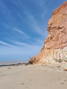 una playa de arena con un acantilado y el océano en Falésias de Marataizes, en Marataízes