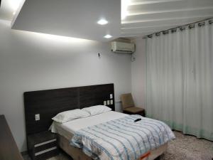 Un dormitorio con una cama con una manta azul y blanca. en Apartamento em Adrianópolis confortável, en Manaus