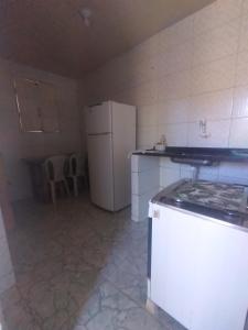 y cocina con nevera y fogones. en Falésias de Marataizes, en Marataízes