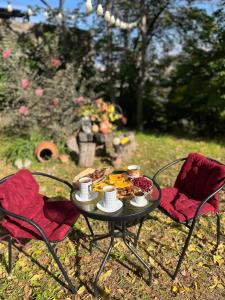 a table with a plate of food and two chairs at Guesthouse Family in Tbilisi City