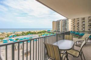 einen Balkon mit Stühlen, einem Tisch und Strand in der Unterkunft Sea Colony - 303N Edgewater House Rd in Sea Colony