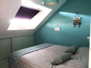 a bedroom with a bed with a blue wall at Grand duplex tout confort, à 2km de la Baie de Cancale - Mt St Michel in La Fresnais