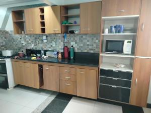 Una cocina con gabinetes de madera y una encimera negra. en Apartamento em Adrianópolis confortável, en Manaus 23 fotos más