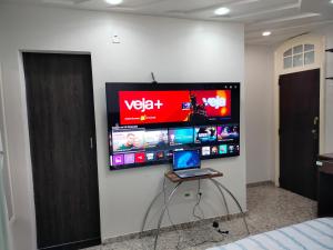 a room with a laptop on a wall with a tv at Apartamento em Adrianópolis confortável in Manaus