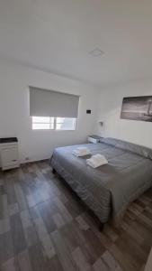 ein Schlafzimmer mit einem Bett mit zwei Handtüchern darauf in der Unterkunft Estrella del Faro in Mar del Plata
