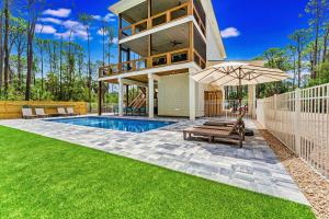a house with a swimming pool and an umbrella at Endless Summer St George 4Bed 3 5 Bath with POOL in St. George Island