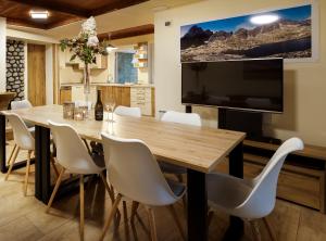 a dining room with a table and a large tv at Chalet Green Park in Stará Lesná