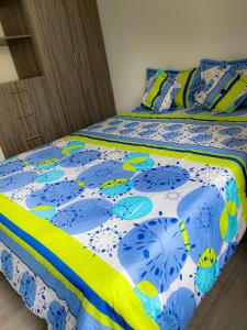 a bed with a blue and white comforter on it at The house of your dreams located in Pitalito! in Pitalito