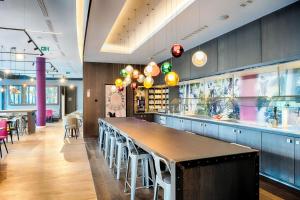a restaurant with a long bar with stools at Premier Inn Heilbronn City Centre in Heilbronn