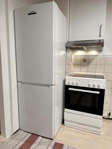 a white refrigerator next to a stove in a kitchen at Norway Lights center of Bodo near Train station and Aeroport in Bodø