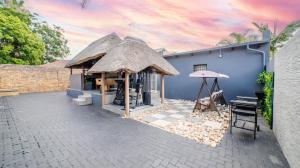 a blue building with a thatch roof at Homes of Ace Diamond in Pretoria +18 photos