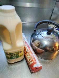 a bottle of milk and a bag of peanuts and a pot of food at Small Rosie River Glamping Pod for 1 in Lincoln