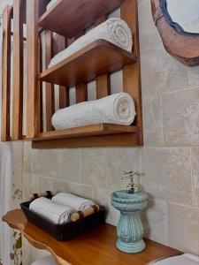 a bathroom with a shelf with towels and a sink at Habitación doble Monarca 2 ó 3 camas in Barichara +7 photos