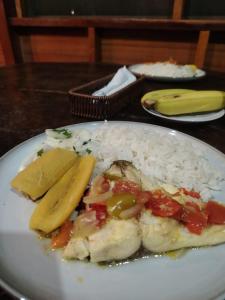 a plate of food with rice and a banana at Musas Garden Lodge Tambopata in Puerto Maldonado
