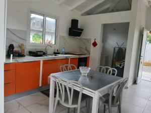 a kitchen with a table and chairs in a room at Maison cosy à Lamentin, 20m², climatisation in Lamentin +19 photos