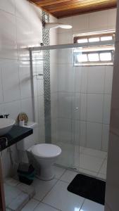 a bathroom with a toilet and a glass shower at Sobrado entrada de Paraty in Paraty