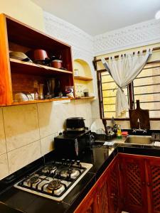 a kitchen with a stove top oven in a kitchen at Jean pierre studio apartment in Malindi +4 photos