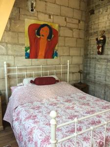 um quarto com uma cama branca e uma pintura na parede em Greenwoods cottage em Valkenburg