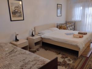 a bedroom with two beds and two night stands at Jakov's apartment in Bitola