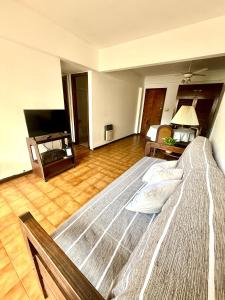 a large bed in a room with a television at Amardel in Mar del Plata