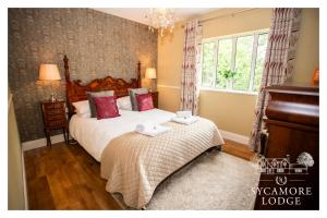 a bedroom with a large bed and a piano at Sycamore Lodge in Kilkee