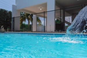 a fountain in a swimming pool in front of a building at Private Pool Home Beach 15 min Drive in Cabo Rojo
