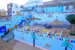 a building painted blue and white with a beach at Nubian Palace Eco Lodge - A Nubian Home Since 1959 in Aswan