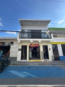Una tienda en una calle con una motocicleta estacionada en frente. en Saman suites, en Alcalá