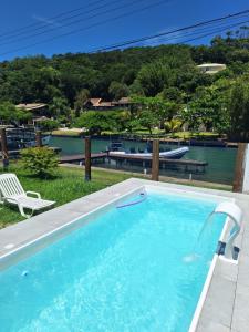 a swimming pool with a view of the water at Floripa Glamping in Florianópolis
