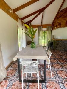 a table with white chairs and a vase with a plant at Tai Rapa Nui in Isla de Pascua