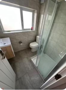 a bathroom with a shower and a toilet and a window at 62 Iveagh close in London