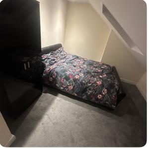 a bed in a room with a flowered blanket at 62 Iveagh close in London