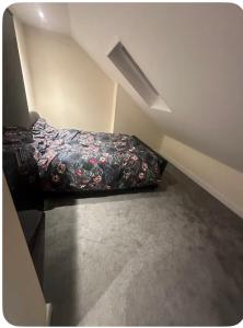 a bedroom with a bed with a flowered blanket at 62 Iveagh close in London