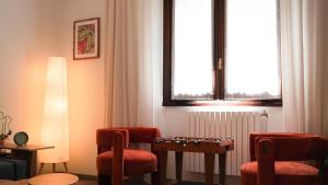 een kamer met stoelen, een tafel en een raam bij Il cuore della valtellina in Caiolo +18 foto's