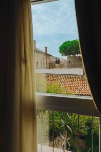 una ventana con vistas a la ciudad desde un edificio en Duomo Room Comacchio, en Comacchio