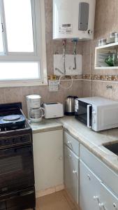 a kitchen with a counter with a stove and a microwave at Departamento Bolívar a 2 cuadras de la costa in Mar del Plata +3 photos