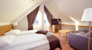 a hotel room with a bed and a window at Clarion Collection Hotel With in Tromsø