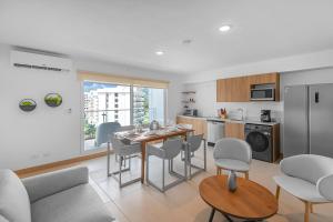 a kitchen and living room with a table and chairs at Upstay Brand New 3BR Viva Jaco Residences in Jacó