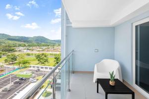 a room with a balcony with a view of a city at Upstay Brand New 3BR Viva Jaco Residences in Jacó
