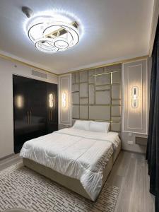 - une chambre avec un grand lit et un grand lustre dans l'établissement เพ้นท์เฮ้าส์ Boulevard - Point Downtown Dubai, à Dubaï