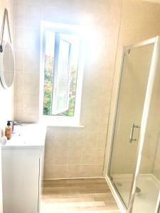 a bathroom with a shower and a sink and a window at Entire Apartment in Pretty Coastal Village in Cubert