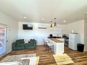 a kitchen and living room with a green couch at Glacier Alpine Escape in East Glacier Park