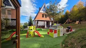 a yard with a playground and a house at Chata Dominika Námestovo in Námestovo