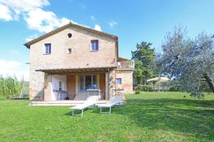 a house with two white chairs in the yard at Fontesecca - Happy Rentals in Città della Pieve