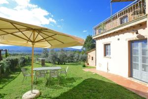 a patio with a table and chairs and an umbrella at Fontesecca - Happy Rentals in Città della Pieve