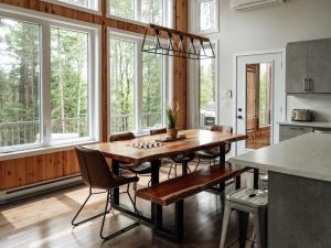 Saint ComeにあるChalet Ankoay - Relaxation Nature & Private Spaのテーブルと椅子と窓のあるダイニングルーム
